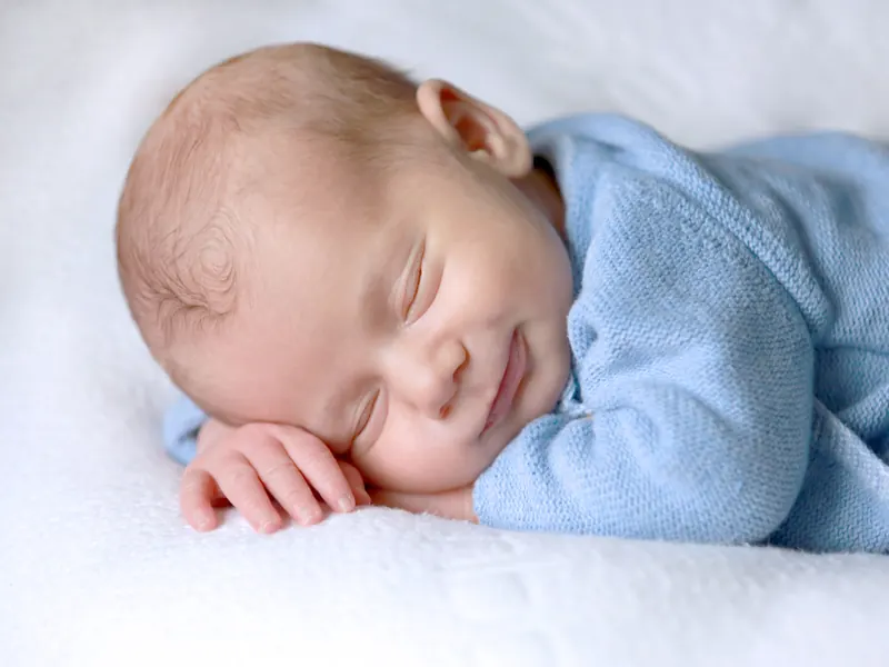 Un bébé sourit en dormant